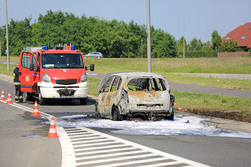 Spalony samochód osobowy na ulicy, pożar ugaszony przez straż pożarną. - obrazy, fototapety, plakaty