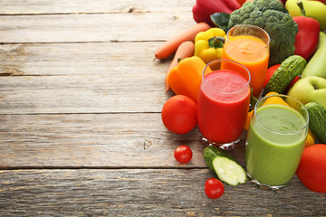 Vegetables smoothie in glasses on grey wooden table