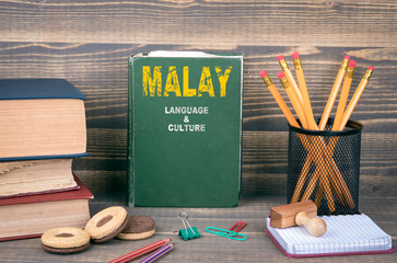 Malay language and culture concept. Book on a wooden background