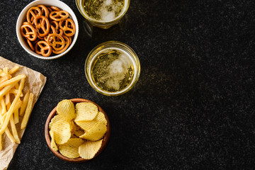 Lager beer and snacks on stone table. Nuts, chips. Top view with copyspace