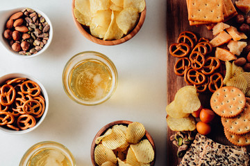 Lager beer and snacks on stone table. Nuts, chips. Top view with copyspace