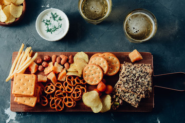 Lager beer and snacks on stone table. Nuts, chips. Top view with copyspace