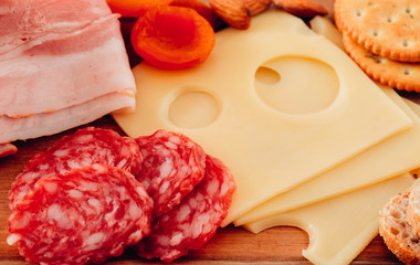 Cheese and meat appetizer selection. Prosciutto di Parma, salami, bread sticks, baguette slices, olives. Top view.