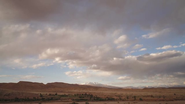 Cloud formations over the Atlas mountains near the ancient Kasbah town of Ait Benhaddou beside the Quarzazate River, Morocco, North Africa, T/Lapse