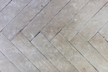 A close-up of an old gray faded parquet covered with dust and dirt. Result of repair. Cleaning and cleaning required