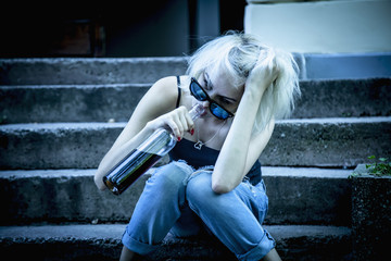 Young female with alcoholic drink looking very sad and depressed. Drunk young people