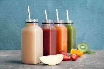 Bottles with healthy detox smoothies and ingredients on table
