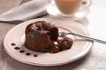 Plate of delicious fresh fondant with hot chocolate on table. Lava cake recipe