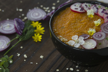 Summer vegetable creme-soup decorated flowers and vegetables