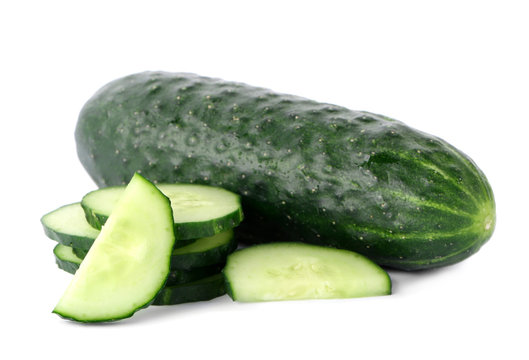 Whole and sliced fresh cucumbers on white background