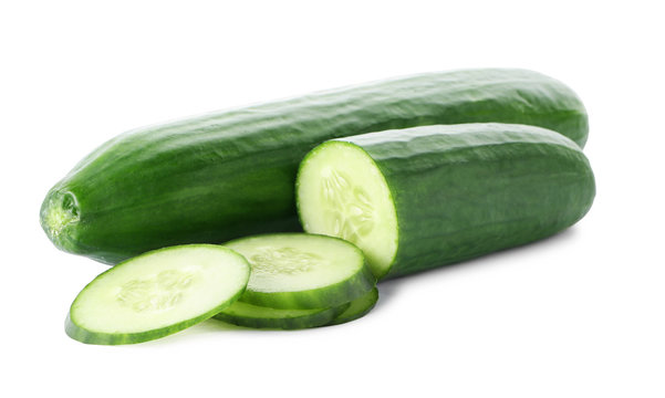 Whole and sliced fresh cucumbers on white background