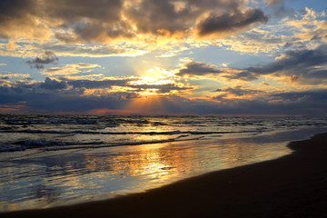 beautiful landscape: cloudy sky and the sea reflects the sun, at sunrise or sunset