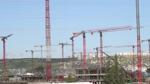 panorama of cranes over building construction at dawn
