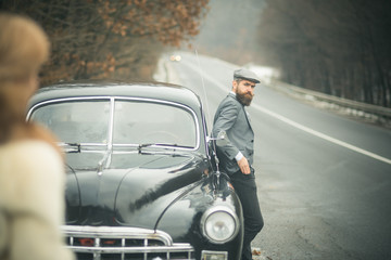 nostalgia concept. nostalgia and retro car at bearded man and woman in coat.