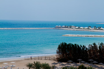 Beautiful blue sea and beach resort huts from al hamra beach view