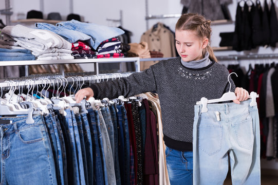 Girl choosing jeans in store