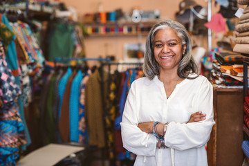 Smiling mature woman standing in her fabric shop