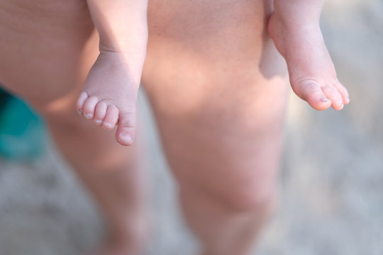 The legs of a woman and the little legs of a baby