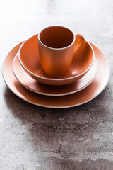 set of plates and a mug on a gray stone table. copy space. modern dishes for lunch, breakfast and dinner