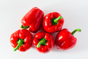 group of red ripe organic bell pepper and fresh basil leaves isolated on white