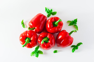 group of red ripe organic bell pepper and fresh basil leaves isolated on white