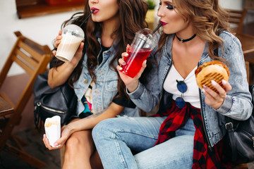 Gorgeous teenagers drinking lemonade and eating fast food