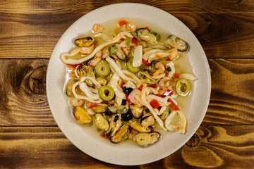 Seafood salad with shrimp, squid and mussels on wooden table