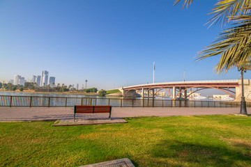 Fototapeta na wymiar Sharjah corniche park with beautiful greenery, union flag and cornice bridge