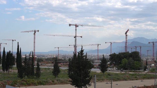 panorama of cranes over building construction at dawn