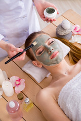 Young woman in spa health concept with face mask
