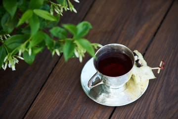 In silence cocktail on wooden table background. Metal cup of alcohol cocktail with cognac and spices, close-up