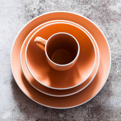 set of plates and a mug on a gray stone table. copy space. modern dishes for lunch, breakfast and dinner