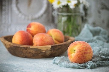 Fresh Peaches in a Wood Bowl on Soft Green Background