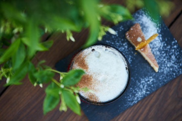 Apple pie flavor cocktail with spices and vanilla ice cream and cognac. Delicious fresh cocktail drink with sweet snack on wooden background, close-up