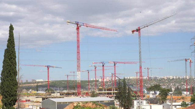 panorama of cranes over building construction at dawn