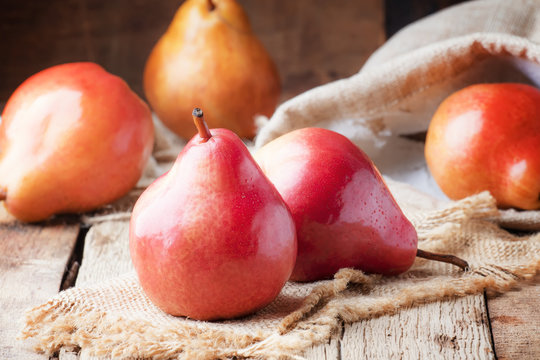 Ripe red pears on rustic wooden background, selective focus