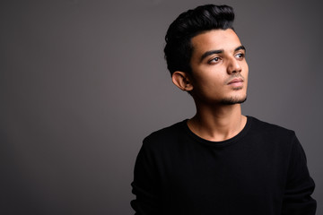 Obraz premium Young Indian man against gray background