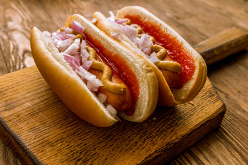 Hot dog with ketchup and mustard and red onions