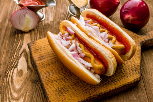 Hot dog with ketchup and mustard and red onions