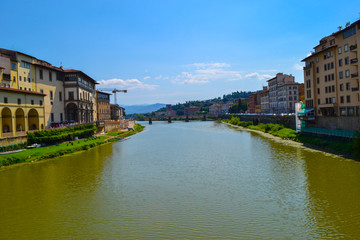 Fototapeta na wymiar Arno river with Ponte alla Carraia (alla Carraia Bridge) at the background. Florence, Italy.