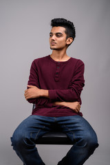 Obraz premium Young Indian man against gray background