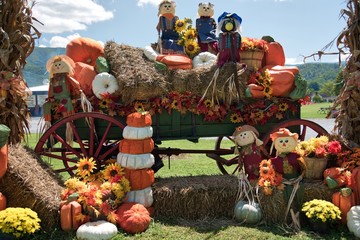 Fall decor of  various pumpkins, hay, and home made dolls.
