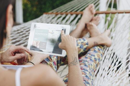 Couple using a tablet in a hammock