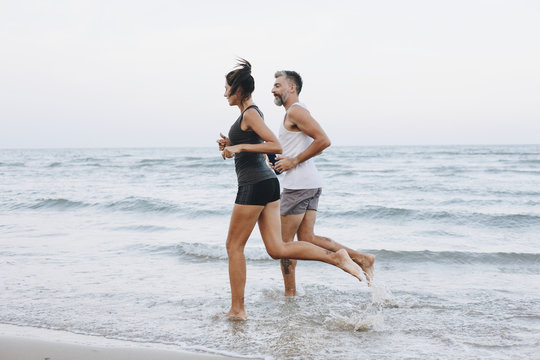 Couple Jogging On A Beach