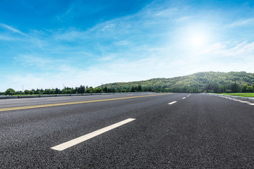 Empty asphalt road and mountains with clouds landscape