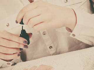 Woman manicurist opening bottle with nail polish