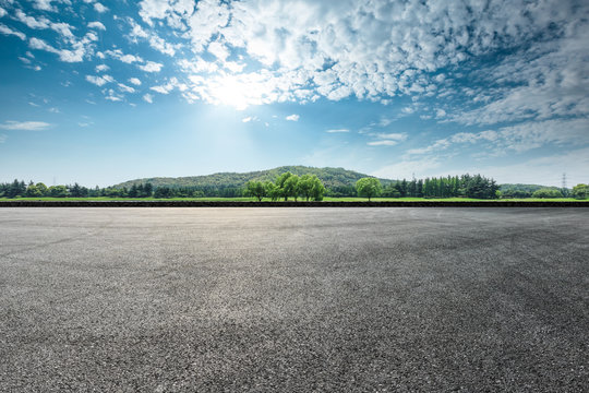 Asphalt square road and hills with sky clouds landscape