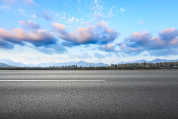 Asphalt road and hills with sky clouds landscape at sunset