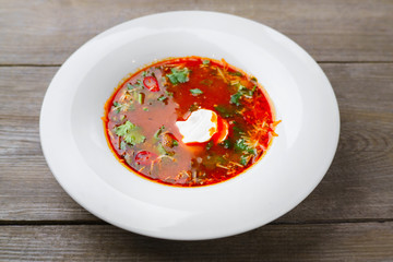 Red borscht, traditional soup made of beetrot, tomato and meat, garnished with sour cream. Ukrainian, Russian, and Polish national cuisine, healthy dinner