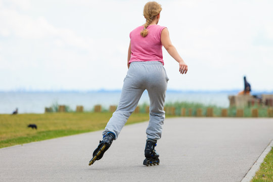 Fit woman on roller skates riding outdoor